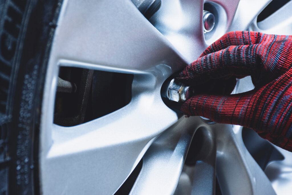 Closeup of a gloved hand twisting a lug not on a wheel