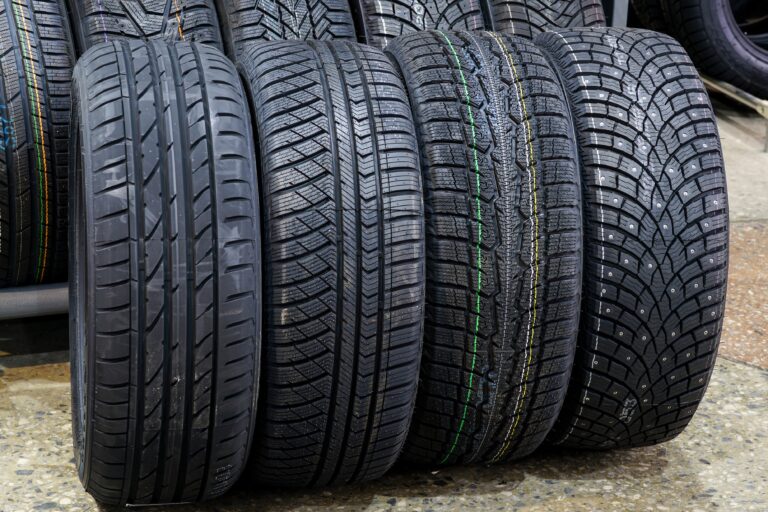 four new tires with different treads for summer, all season, winter with soft rubber and winter with studs