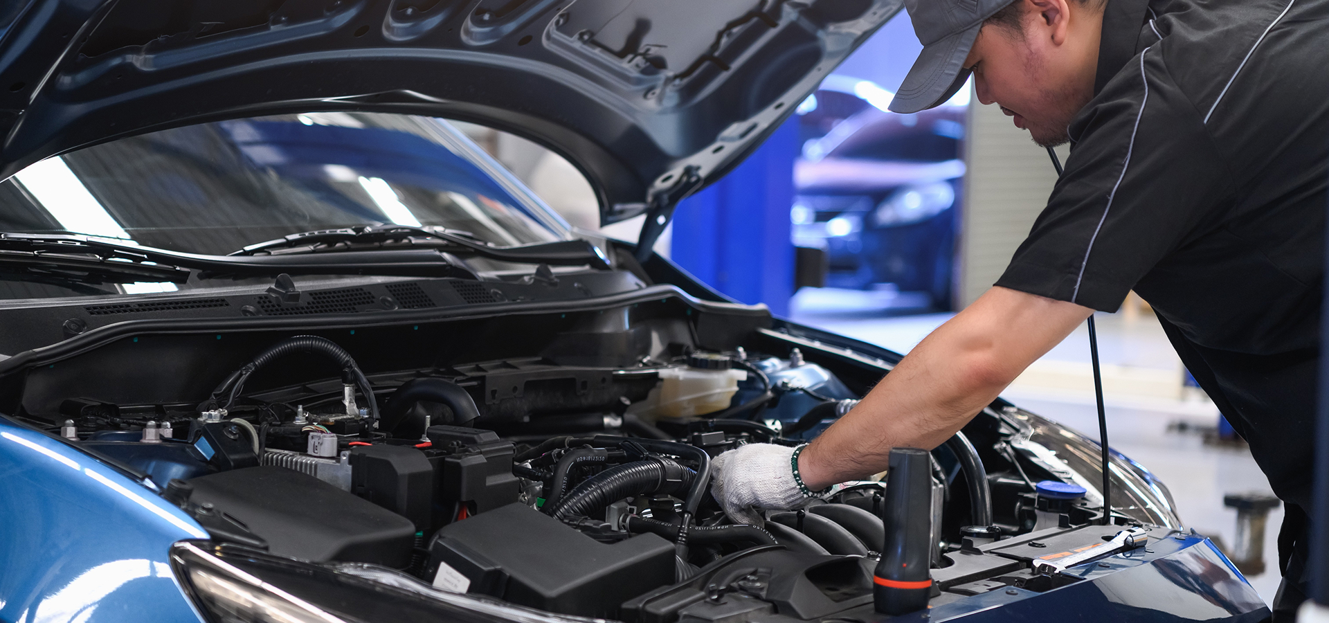 A Telle Tire mechanic working on an engine during a car tune-up service.