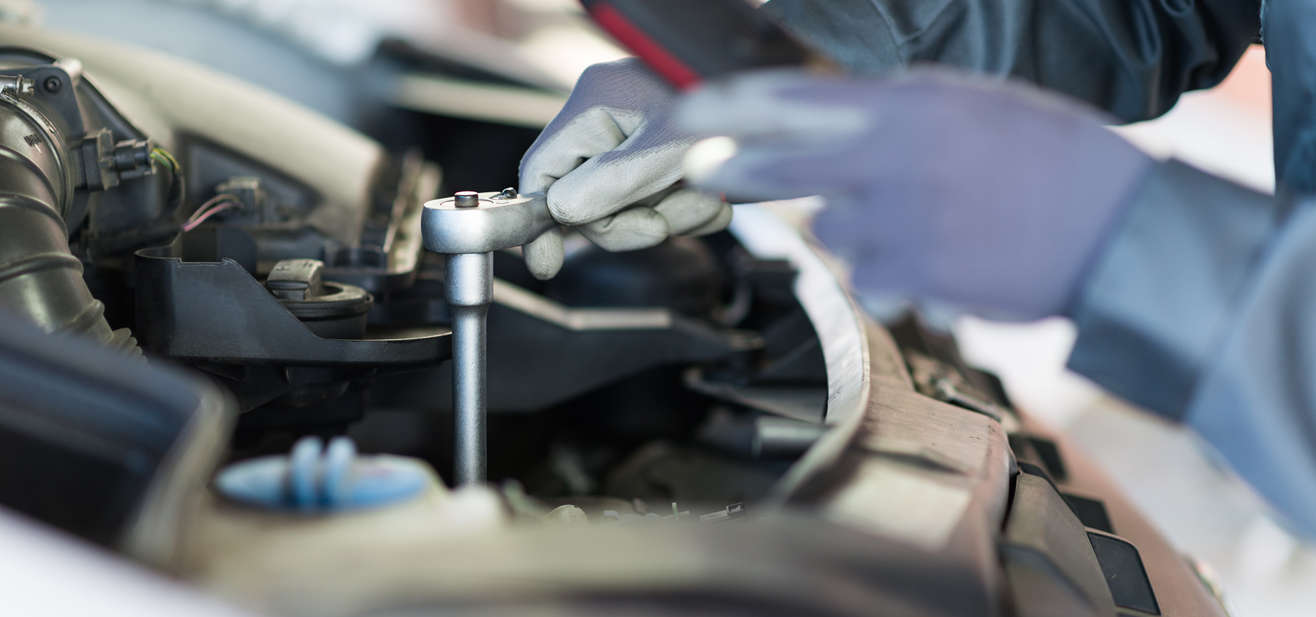 Closeup of a Telle Tire mechanic's hands performing repairs under the hood of a commercial vehicle for a fleet partner.