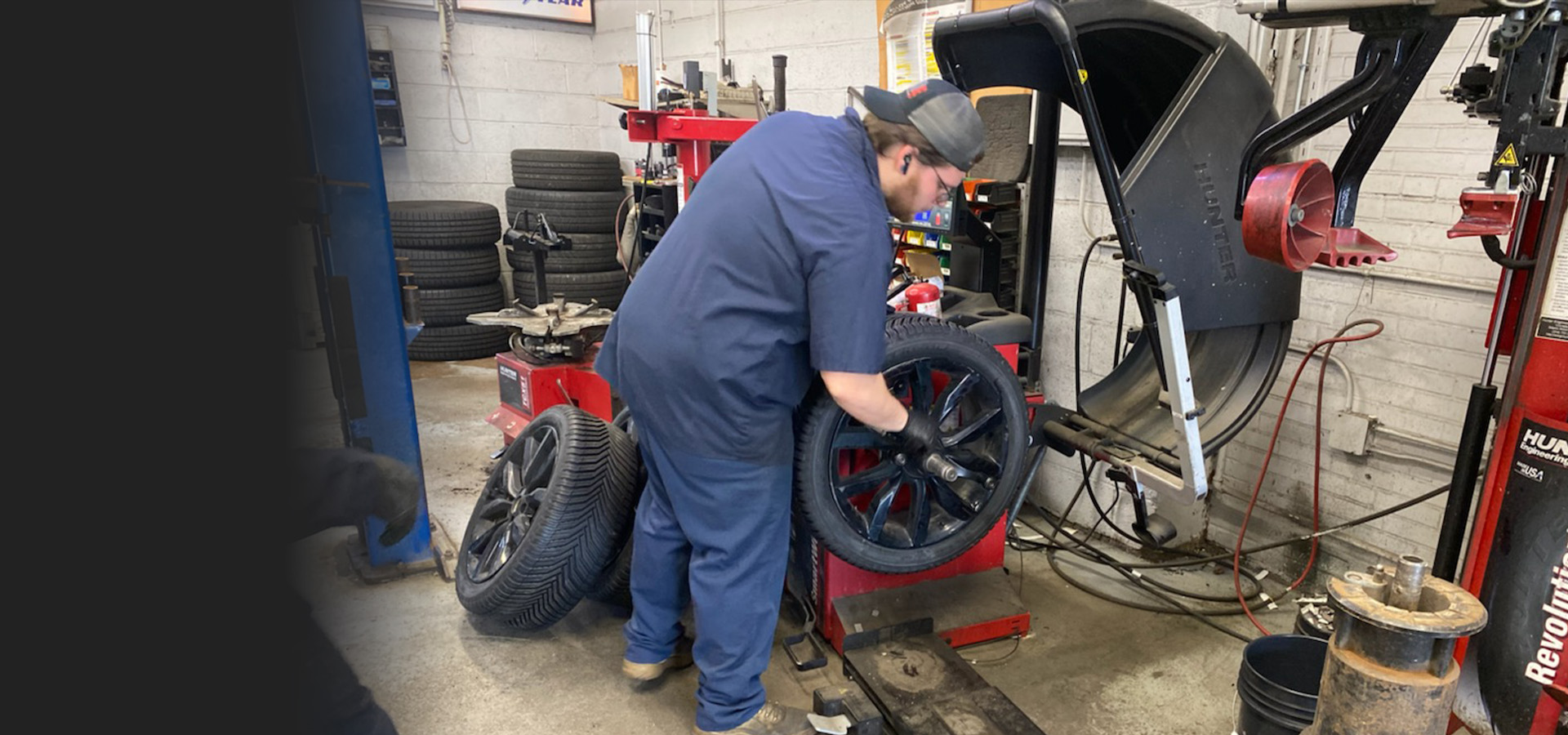 A Telle Tire technician working in the shop to mount a new tire to a wheel rim.