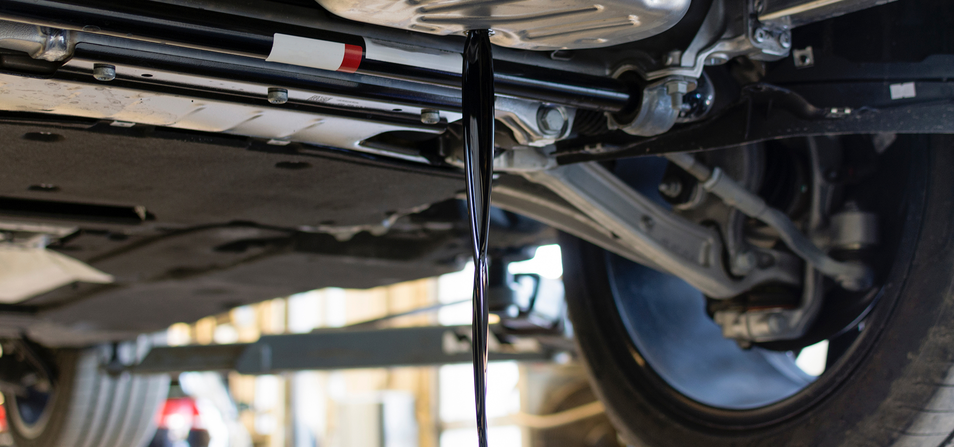 Engine oil being drained from a vehicle during Telle Tire's oil change service.