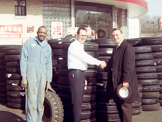 Third-generation Telle Tire & Auto Service owners Scott Telle, and his brother, Mark, out front of the location shaking hands.