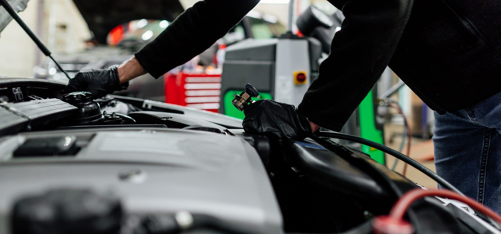 A Telle Tire mechanic performing radiator & cooling system maintenance on a vehicle.