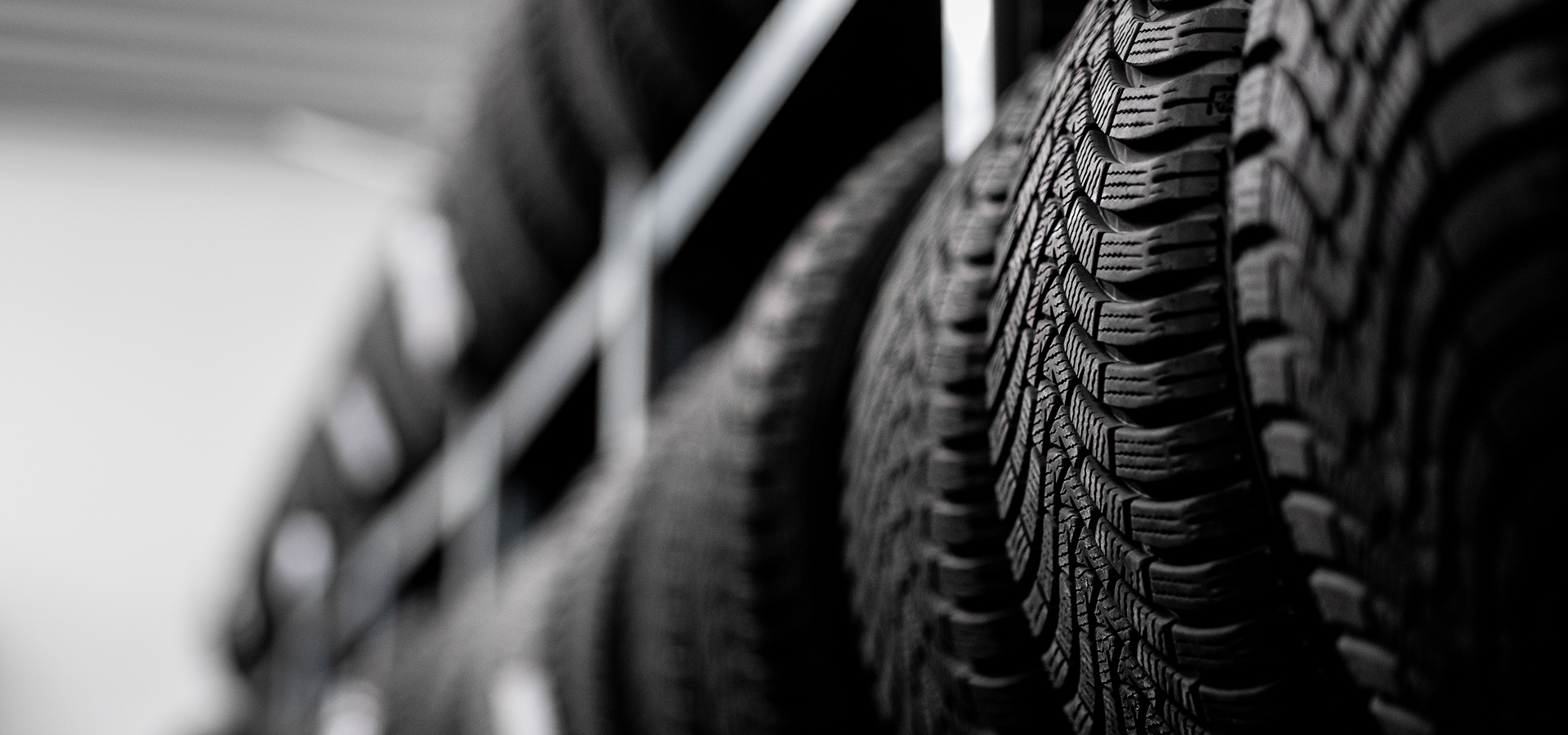 Several brand new tires, lining the shelves of a tire rack at Telle Tire.