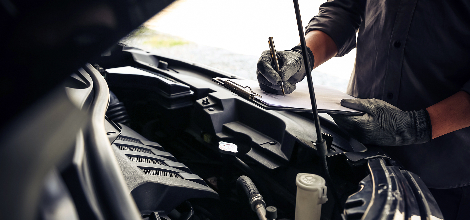 Telle Tire mechanic, performing Missouri State Inspection and Emissions testing, checking off items on a checklist.