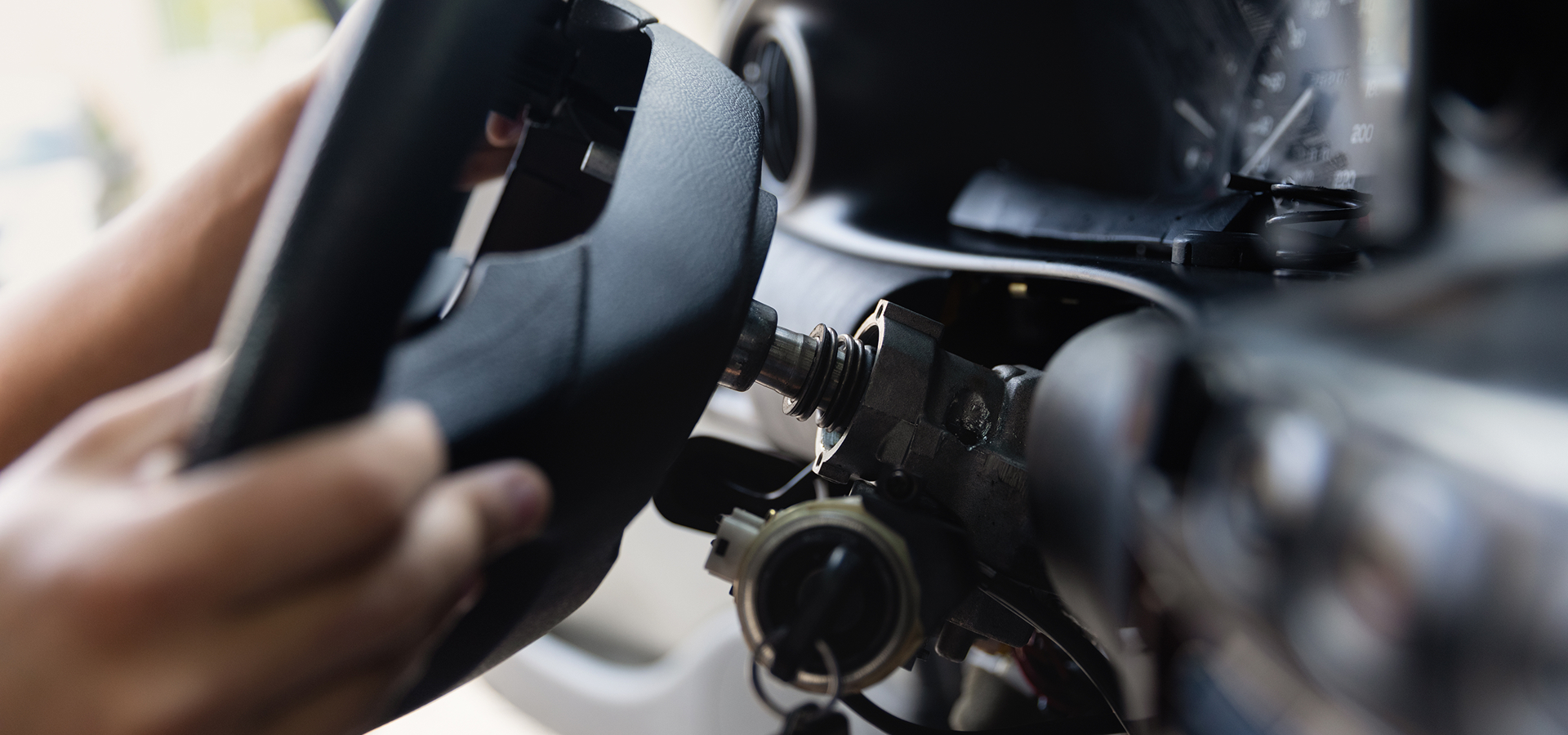 A steering wheel of a vehicle with internal components connected into the dashboard and steering system exposed.