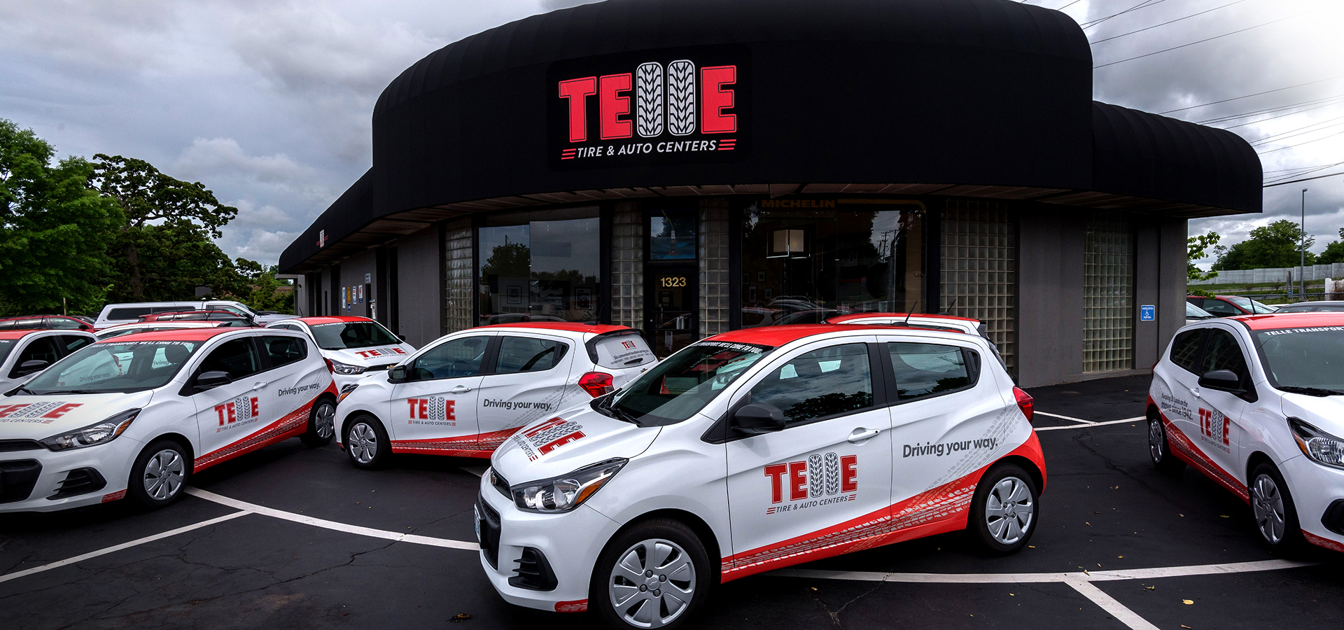 The front of the original Telle Tire location with numerous Telle branded vehicles parked out front.