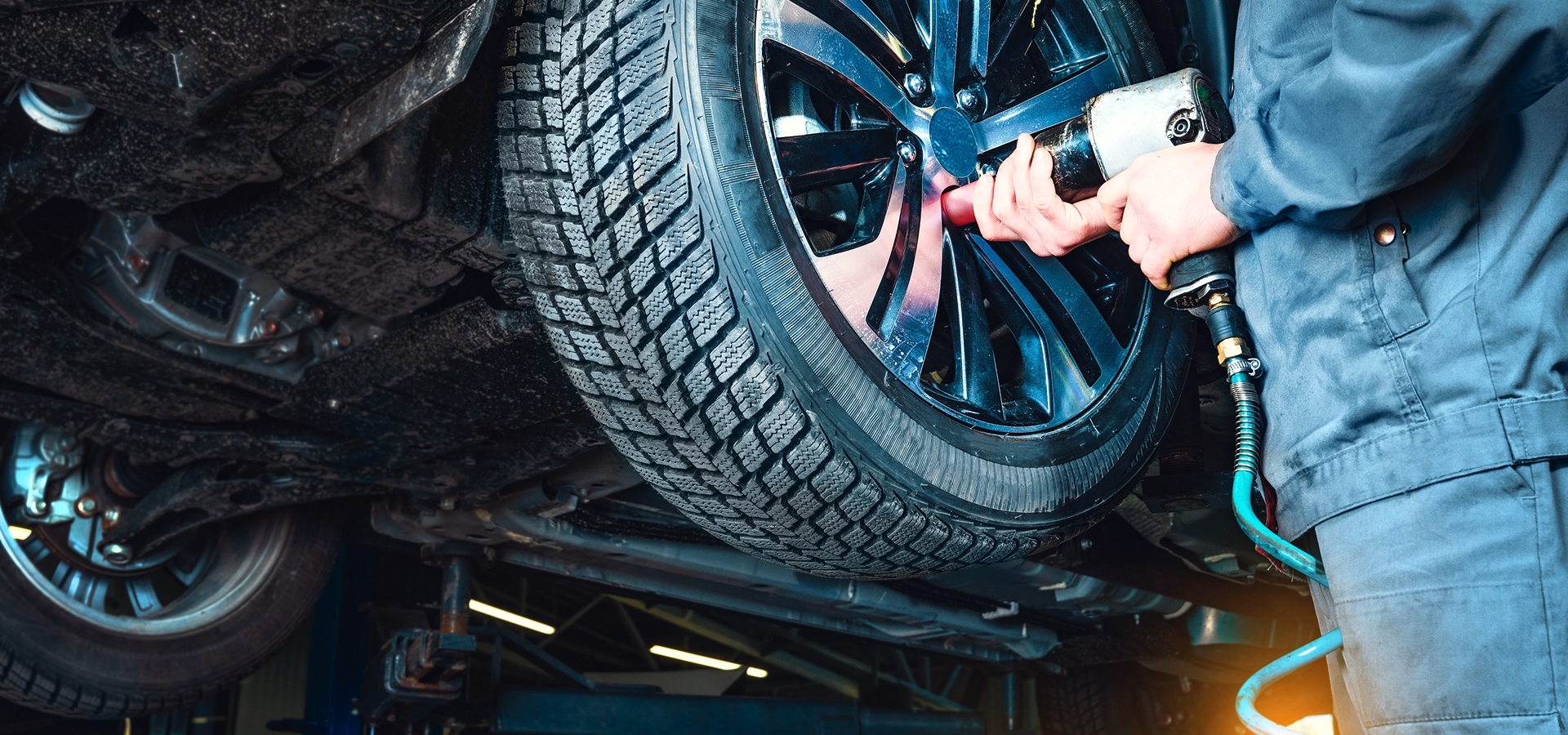 A Telle Tire technician using an impact wrench to secure the lug nuts on a vehicle during the tire rotation service.