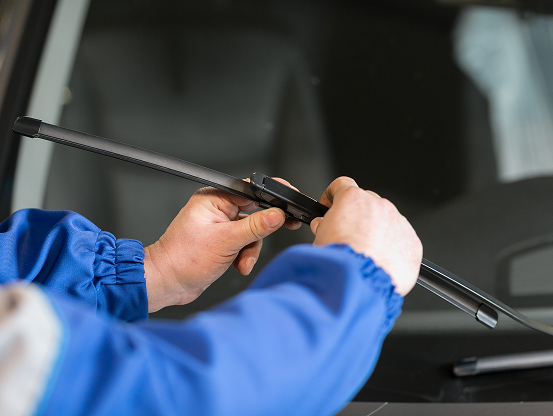 A Telle Tire technician replacing the wiper blades on a vehicle for a customer.
