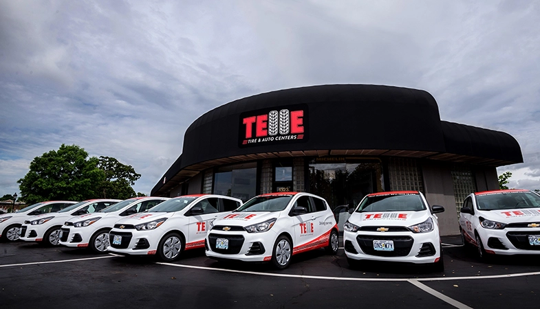 A front view of the Telle Tire & Auto Centers Richmond Heights, MO, location with Telle branded vehicles parked out front.